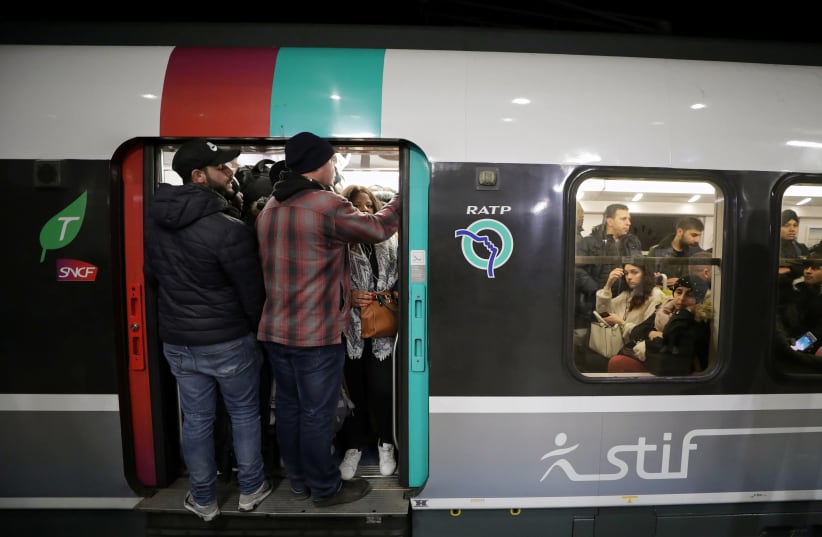 Passengers stand in the door of a packed metro train at the Gare du Nord RER station in Paris (photo credit: REUTERS/ERIC GAILLARD)