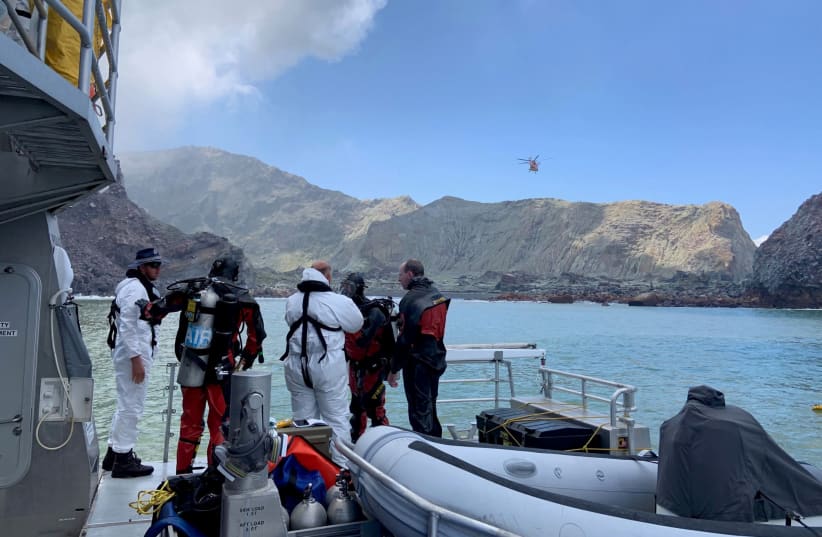 Members of a dive squad conduct a search during a recovery operation around White Island, which is also known by its Maori name of Whakaari, a volcanic island that fatally erupted earlier this week, in New Zealand, December 13, 2019 (photo credit: NEW ZEALAND POLICE/VIA REUTERS)