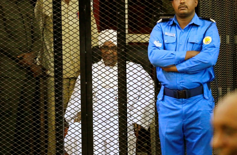 Sudanese former president Omar Hassan al-Bashir sits inside a cage during the hearing of the verdict that convicted him of corruption charges in a court in Khartoum, Sudan. December 14, 2019 (photo credit: REUTERS/MOHAMED NURELDIN ABDALLAH)