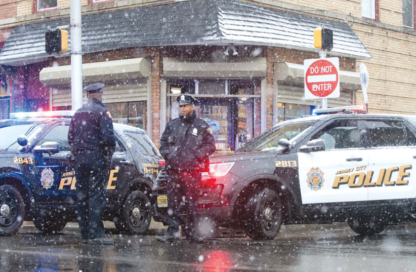 JERSEY CITY police work at the scene the day after an hours-long gun battle with two men around a kosher market in Jersey City, New Jersey. (photo credit: REUTERS)