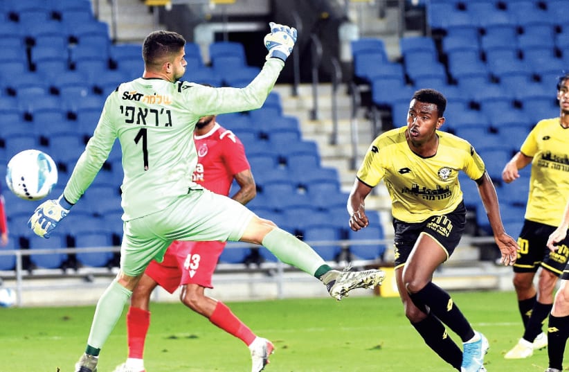 YONAS MALADA (right) and Maccabi Netanya bombarded Hapoel Tel Aviv ’keeper Yoav Gerafi on Sunday night, scoring early and often in a 4-0 victory over the Reds. (photo credit: BERNEY ARDOV)