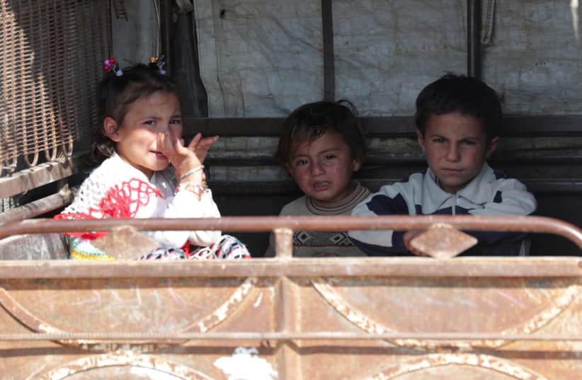 Children sit in an auto rickshaw in Tal Abyad, one of the cities in which Turkish President Tayyip Erdogan plans to resettle Syrian refugees (photo credit: KHALIL ASHAWI / REUTERS)
