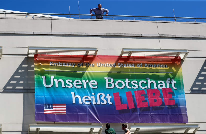 U.S. Ambassador to Germany Richard Grenell watches as workers attach a banner, which reads "Our message is love", at the U.S. Embassy ahead of the Gay Pride parade, also called Christopher Street Day (CSD) parade in Berlin, Germany (photo credit: REUTERS/FABRIZIO BENSCH)