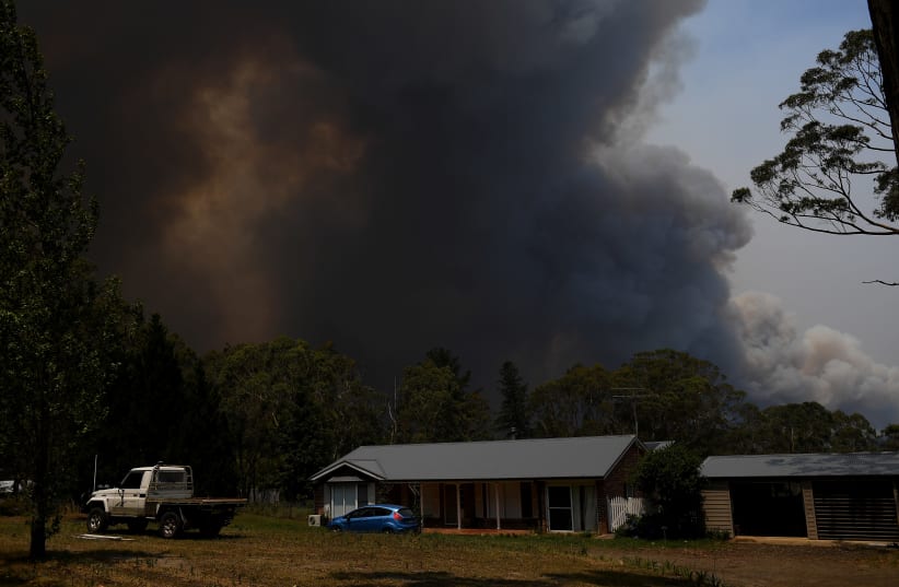 A home is seen as smoke from the Grose Valley Fire rises in the distance, at Bilpin, New South Wales, Australia, December 21, 2019 (photo credit: AAP IMAGE/DAN HIMBRECHTS VIA REUTERS)