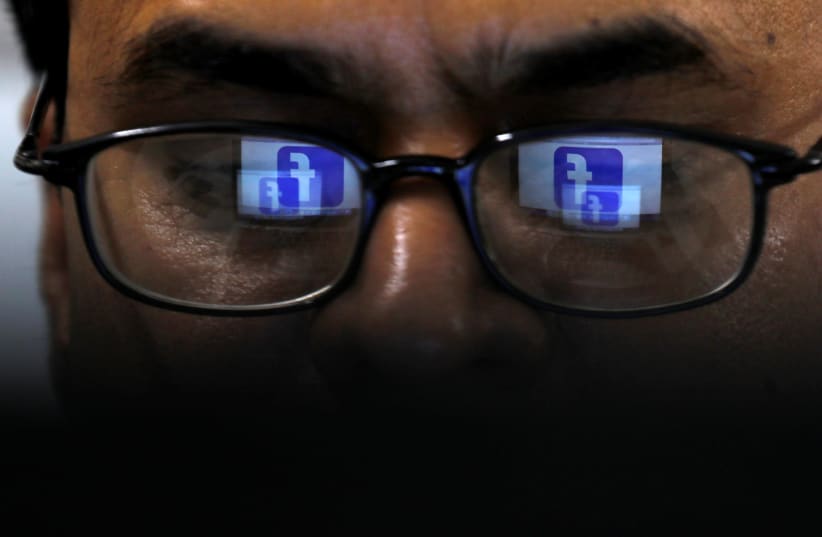 Facebook logo is reflected in glasses in this picture illustration taken April 1, 2019 (photo credit: REUTERS/AKHTAR SOOMRO/ILLUSTRATION)