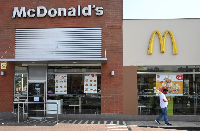 A person walks next to a closed McDonald's restaurant, one of all 29 locations that were closed following the deaths of two teenaged employees, in Lima, Peru  (photo credit: REUTERS/GUADALUPE PARDO)
