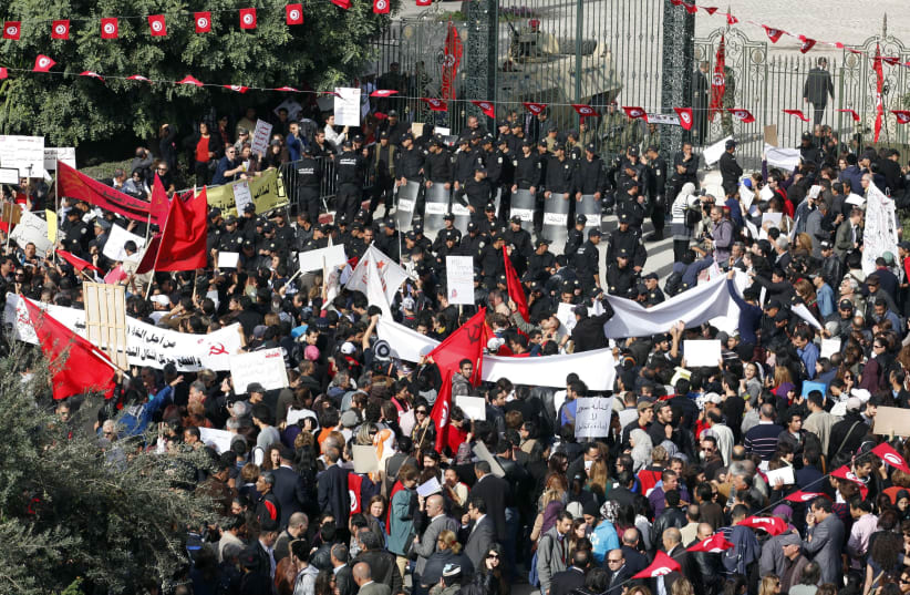 Protesters stand in front of riot police during a demonstration outside the parliamentary building in Tunis, November 2011 (photo credit: REUTERS/ZOUBEIR SOUISSI)