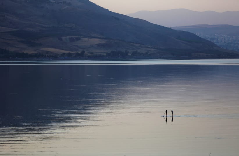 People paddle on a stand-up paddle board in the Sea of Galilee, northern Israel November 8, 2016. (photo credit: REUTERS/Ronen Zvulun)