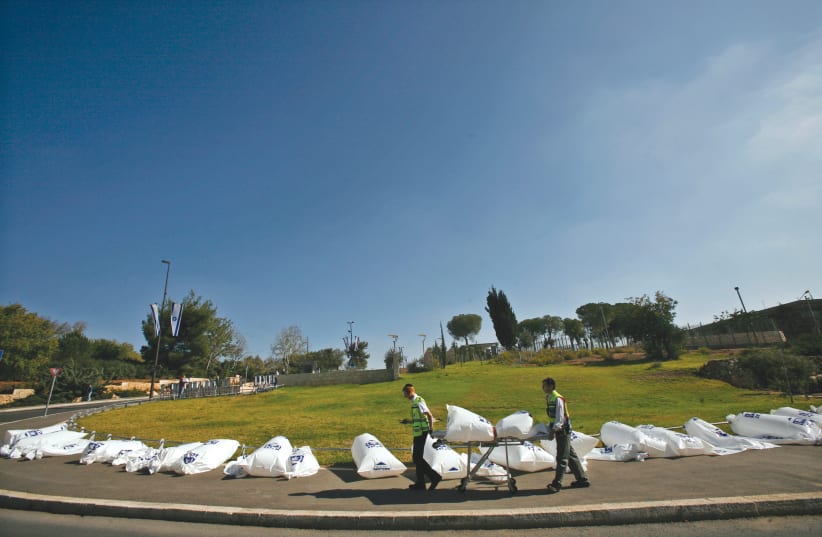 Members of the ZAKA rescue service display empty body bags outside the Knesset in Jerusalem in a Road Safety Awareness event. (photo credit: BAZ RATNER/REUTERS)