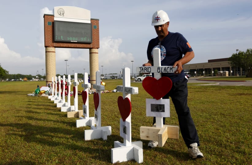 Greg Zanis places crosses bearing the names of the victims killed in a shooting at Santa Fe High School in Santa Fe, Texas, U.S., May 21, 2018 (photo credit: JONATHAN BACHMAN/REUTERS)