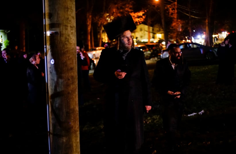 Jewish people try to take a look of the area where 5 people were stabbed at a Hasidic rabbi's home in Monsey, New York (photo credit: REUTERS)