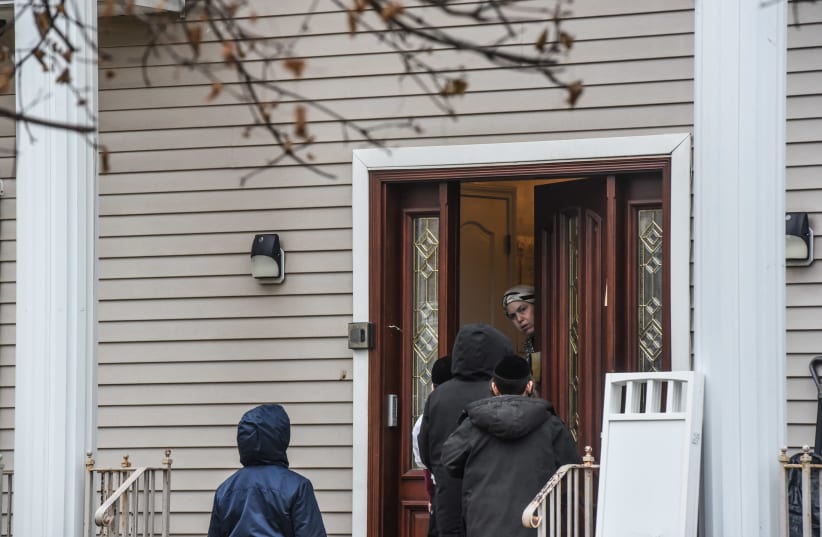 A person answers the door at the house of Rabbi Chaim Rottenberg on December 29, 2019 in Monsey, New York. Five people were injured in a knife attack during a Hanukkah party and a suspect was later arrested in Harlem. (photo credit: STEPHANIE KEITH/ GETTY IMAGES)
