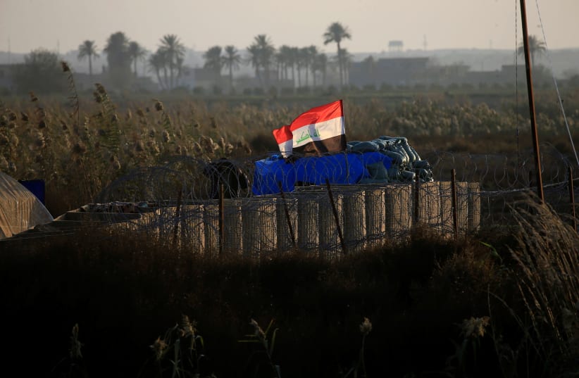 An Iraqi flag flies at a military camp near the border with Syria at al-Qaim, Iraq, November 25, 2018. (photo credit: ALAA AL-MARJANI/REUTERS)
