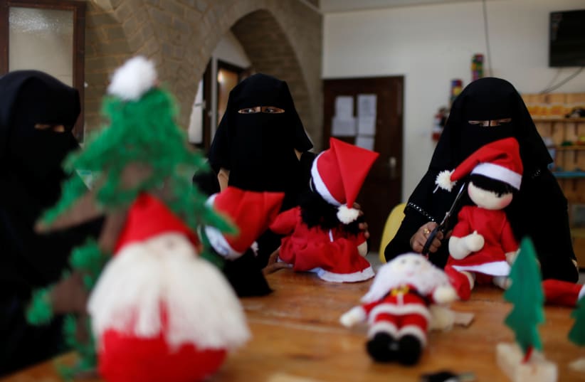 Palestinian women wearing face veil, niqab, make Santa-themed Christmas toys in the northern Gaza Strip (photo credit: REUTERS)
