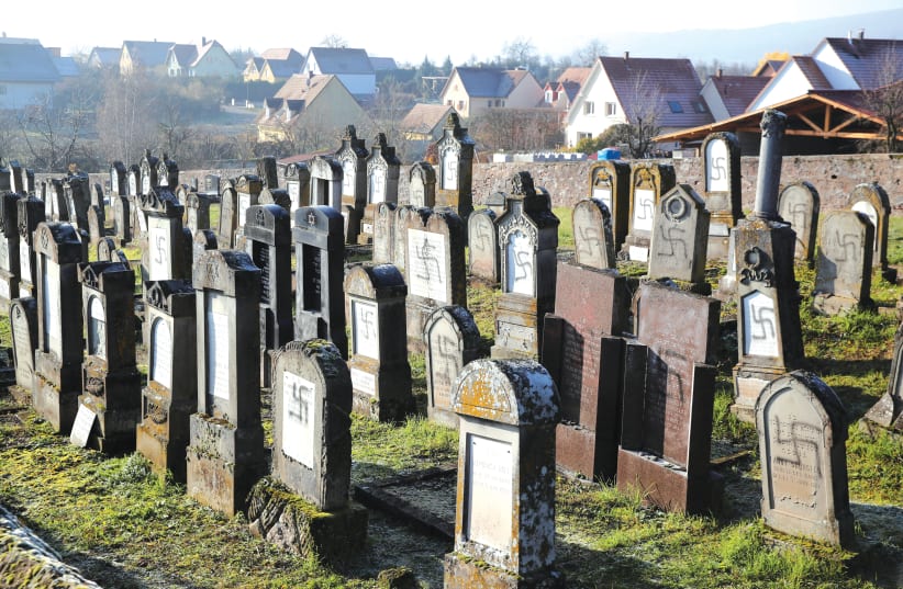 GRAVES DESECRATED with swastikas are seen at the Jewish cemetery in Westhoffen, France.  (photo credit: REUTERS)