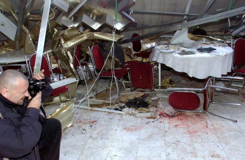 A press photographer pictures the damage to the Hotel Park in Netanya in 2002. A Palestinian suicide bomber blew himself up in the hotel killing 30 people (photo credit: REUTERS)