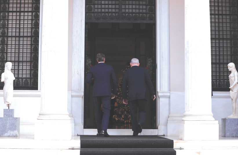 Greek Prime Minister Kyriakos Mitsotakis welcomes Prime Minister Benjamin Netanyahu at the Maximos Mansion in Athens yesterday.  (photo credit: ALKIS KONSTANTINIDIS / REUTERS)