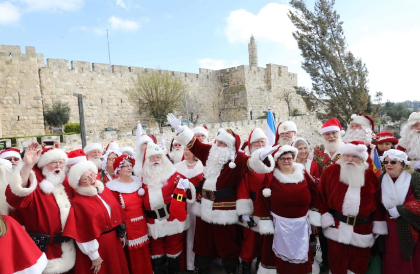 Several Santas in front of the Old City walls of Jerusalem  (photo credit: MARC ISRAEL SELLEM)