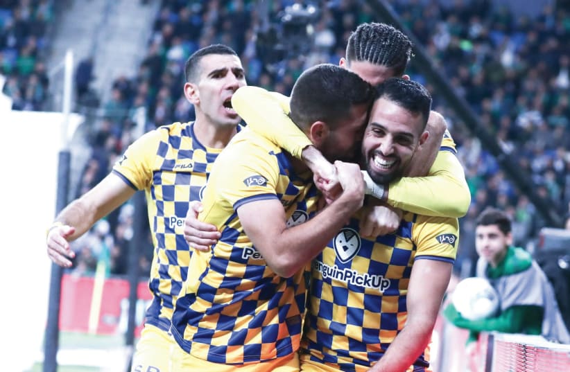 MACCABI TEL AVIV midfielder Eyal Golasa (23) celebrates with his teammates after scoring the yellow-and-blue’s second goal in its 4-3 victory at Maccabi Haifa last night. (photo credit: DANNY MARON)