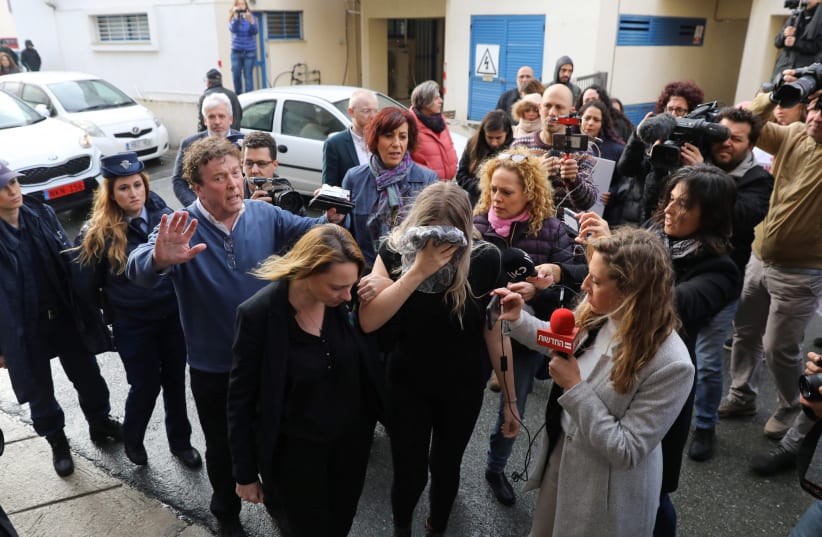 A British woman, accused of lying about being gang raped, covers her face as she arrives at the Famagusta courthouse in Paralimni, Cyprus, January 7, 2020 (photo credit: REUTERS/YIANNIS KOURTOGLOU)