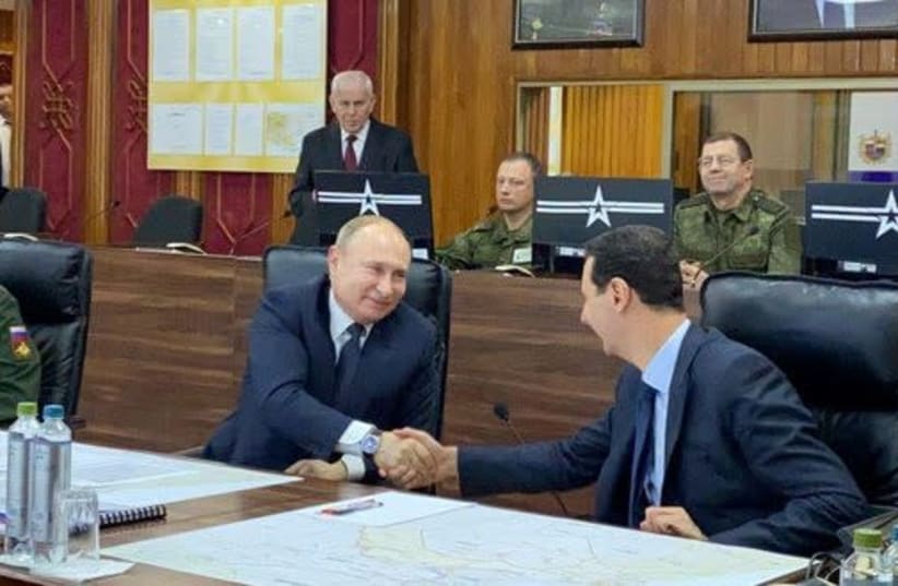 Russian President Vladimir Putin shakes hands with Syria's President Bashar al-Assad in Damascus, Syria in this handout released by SANA on January 7, 2020.  (photo credit: REUTERS)