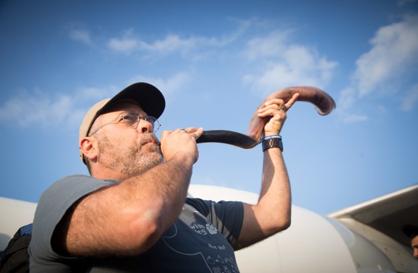 Man blowing the shofar at Ben-Gurion International Airport. (photo credit: HILEL MEIR/TPS)