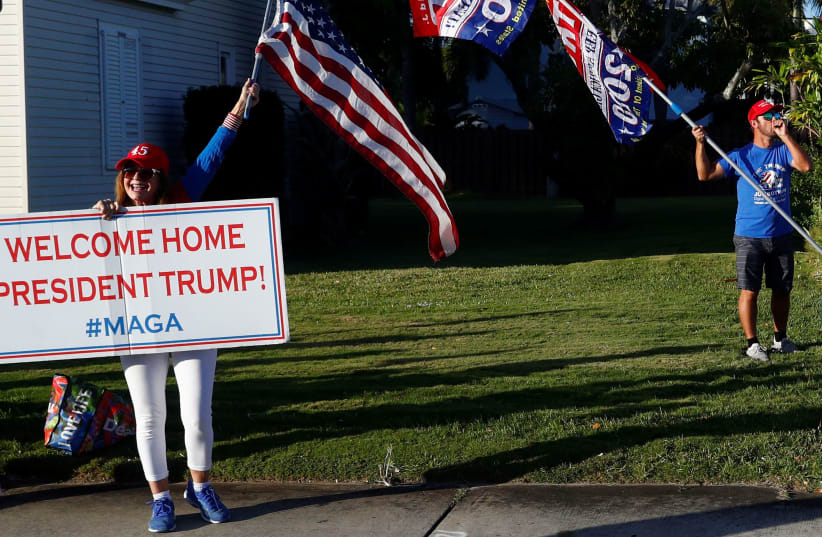PRO-TRUMP demonstrators display signs of support as the presidential motorcade drives to Palm Beach International Airport, in Florida on January 5. (photo credit: REUTERS//TOM BRENNER)