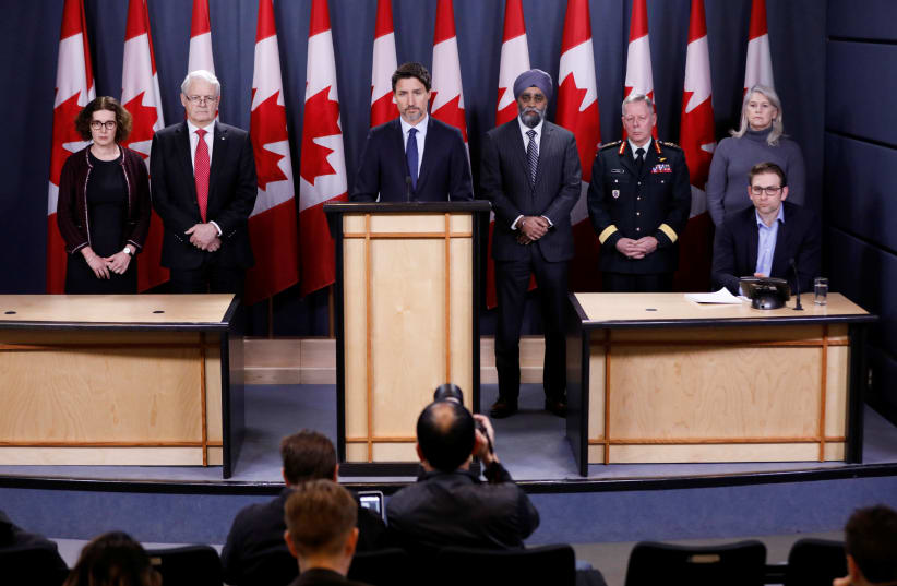 Canada's Prime Minister Justin Trudeau (C), with Deputy Minister of Foreign Affairs Marta Morgan (L), Minister of Transport Marc Garneau, Minister of National Defence Harjit Sajjan, Chief of the Defence Staff General Jonathan Vance, and Deputy Minister of National Defence Jody Thomas (R), attend a n (photo credit: REUTERS//BLAIR GABLE)