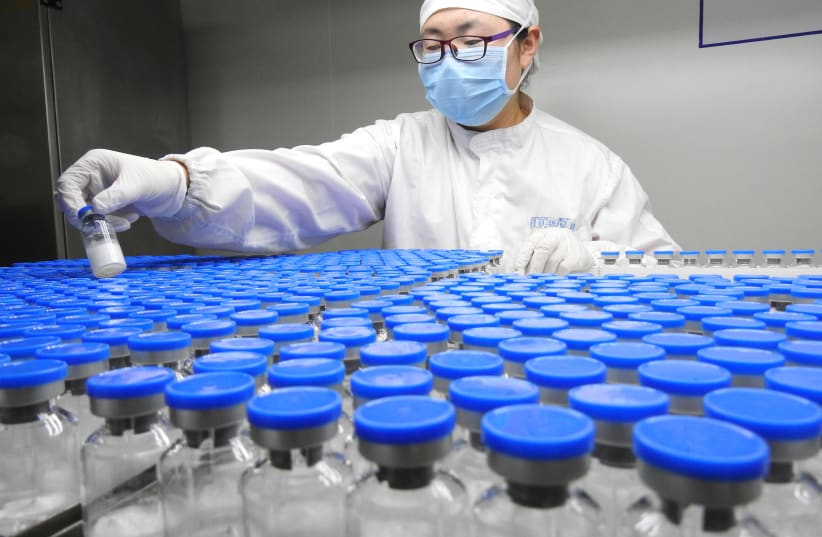 A technician inspects anti-cancer drugs in vials at a lab of a pharmaceutical company in Lianyungang, Jiangsu province, China March 13, 2019 (photo credit: REUTERS/STRINGER)