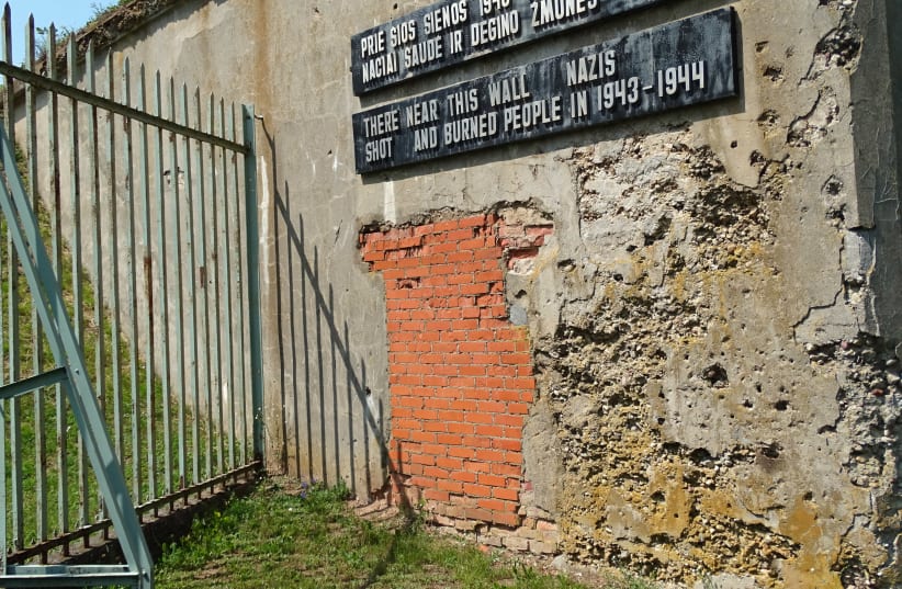 Sign with Battle-Scarred Wall - Ninth Fort - Nazi Genocide Site - Kaunas - Lithuania (photo credit: ADAM JONES/WIKIMEDIA COMMONS)