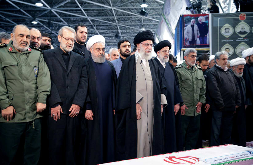 FILE PHOTO: Iran's Supreme Leader Ayatollah Ali Khamenei and Iranian President Hassan Rouhani pray near the coffin of Iranian Major-General Qassem Soleimani, head of the elite Quds Force, who was killed in an air strike at Baghdad airport, in Tehran, Iran, January 6, 2020. Official President's websi (photo credit: REUTERS)