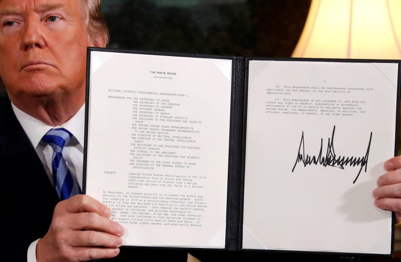 U.S. President Donald Trump holds up a proclamation declaring his intention to withdraw from the JCPOA Iran nuclear agreement after signing it in the Diplomatic Room at the White House in Washington (photo credit: REUTERS/JONATHAN ERNST)