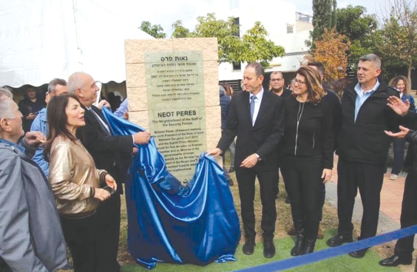 YONI PERES (left) and Acre Mayor Shimon Lankri unveil the plaque of a renamed neighborhood named in memory of Israel’s ninth president, Shimon Peres. (photo credit: COURTESY PERES CENTER)