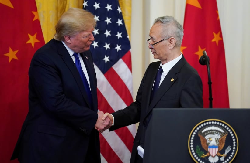 U.S. President Donald Trump shakes hands with Chinese Vice Premier Liu He during a signing ceremony for "phase one" of the U.S.-China trade agreement in the East Room of the White House in Washington, U.S., January 15, 2020 (photo credit: KEVIN LAMARQUE/REUTERS)