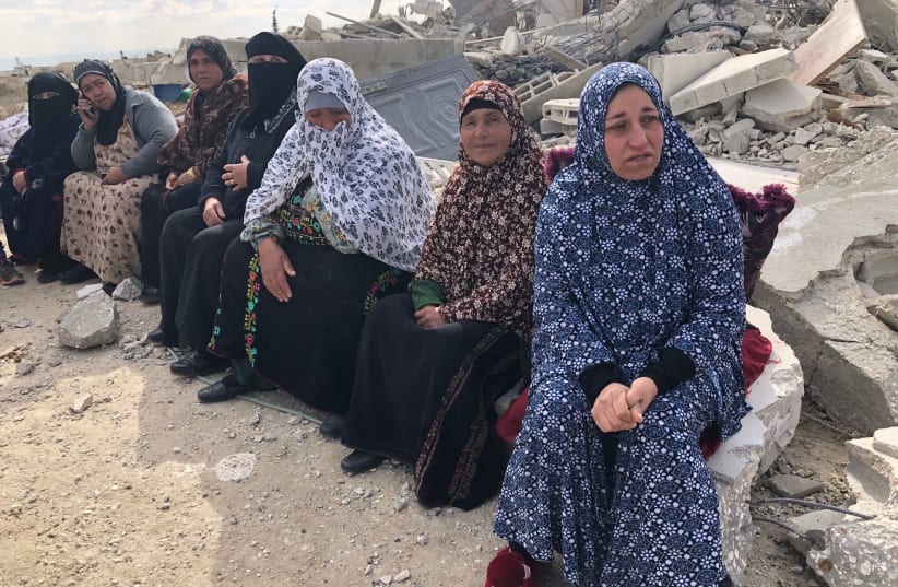 Palestinians in the Ar Rifa'iyya village sit by the rubble fo the Rib'i family home, demolished Thursday by Israeli security forces in the South Hebron Hills. (photo credit: TOVAH LAZAROFF)