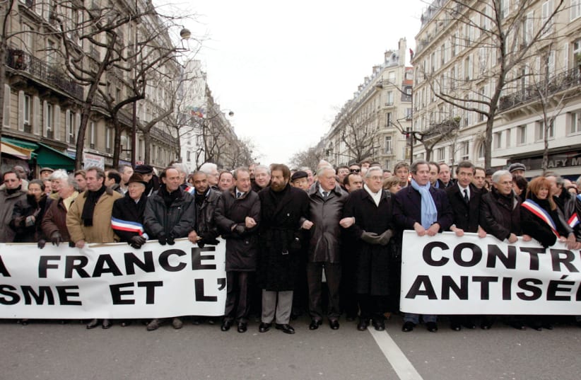 Politicians and religious leaders hold a banner reading 'France against racism and antisemitism' as they take part in a silent march through Paris in 2006 following the torture and killing of young Jewish victim Ilan Halimi. (photo credit: REUTERS/REGIS DUVIGNAU)
