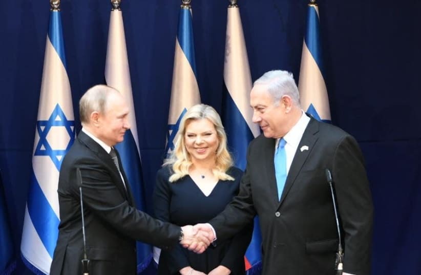 Russian President Vladimir Putins meets Prime Minister Benjamin Netanyahu and wife Sarah, ahead of the Fifth World Holocaust Forum, Janaury 23, 2020 (photo credit: AMOS BEN GERSHOM, GPO)