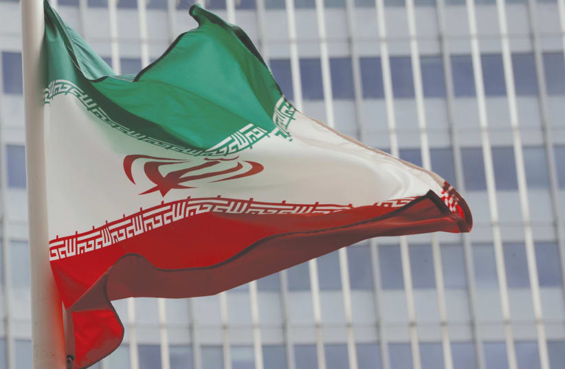 AN IRANIAN FLAG flutters in front of the International Atomic Energy Agency headquarters in Vienna last year (photo credit: REUTERS/LEONHARD FOEGER)