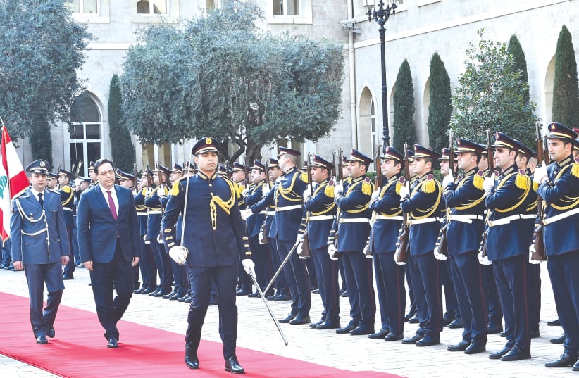 LEBANON’S PRIME MINISTER Hassan Diab reviews an honor guard at the government palace in Beirut earlier this week (photo credit: REUTERS)