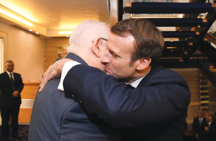 PRESIDENT REUVEN RIVLIN and French President Emmanuel Macron share a warm embrace on Wednesday in Jerusalem (photo credit: HAIM ZACH/GPO)