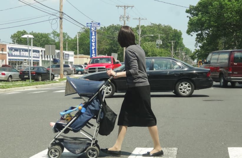 An Orthodox woman pushes a stroller in Lakewood, N.J. in 2013. The population in the largely haredi Orthodox town has boomed in the past couple of decades, and haredi families are looking to move to neighboring towns (photo credit: DENNIS FRAEVICH/FLICKR VIA JTA)
