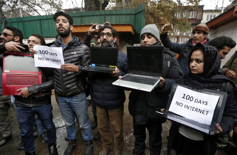 FILE PHOTO: Kashmiri journalists display laptops and placards during a protest demanding restoration of internet service, in Srinagar, November 12, 2019 (photo credit: REUTERS/DANISH ISMAIL/FILE PHOTO)
