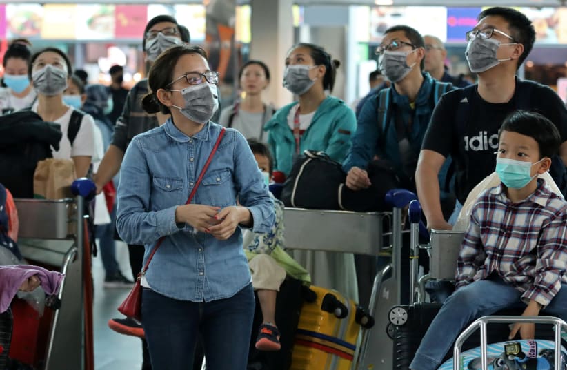 Passengers wearing masks are seen at Kuala Lumpur International Airport 2 in Sepang, Malaysia, January 27, 2020 (photo credit: REUTERS/LIM HUEY TENG)