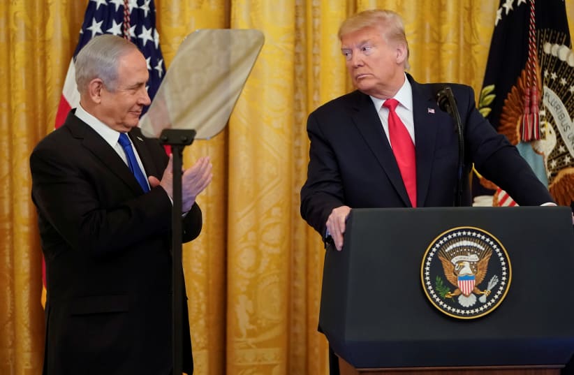U.S. President Donald Trump looks over at Israel's Prime Minister Benjamin Netanyahu during a joint news conference to announce a new Middle East peace plan proposal in the East Room of the White House in Washington, U.S., January 28, 2020 (photo credit: REUTERS/JOSHUA ROBERTS)