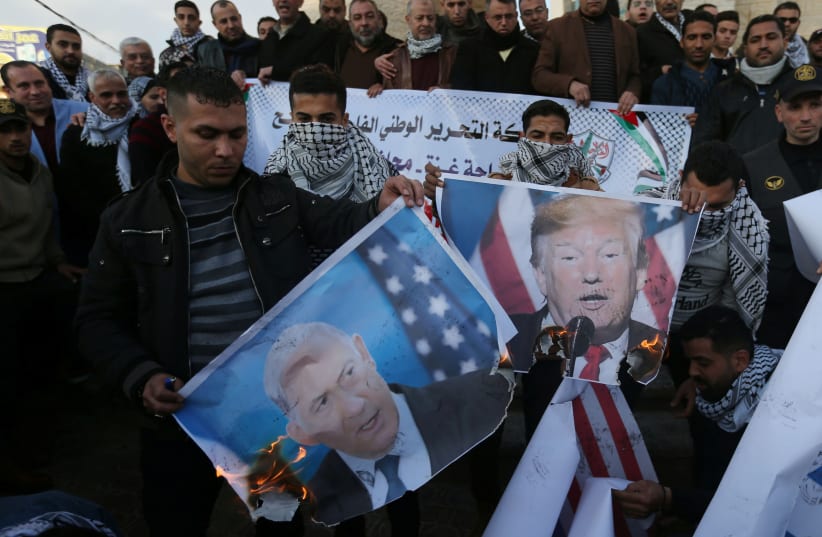 Palestinian demonstrators burn pictures depicting U.S. President Donald Trump and Israeli Prime Minister Benjamin Netanyahu, and representations of U.S and Israeli flags during a protest against the U.S. President Donald Trump's Middle East peace plan, in the southern Gaza Strip January 29, 2020.  (photo credit: IBRAHEEM ABU MUSTAFA / REUTERS)