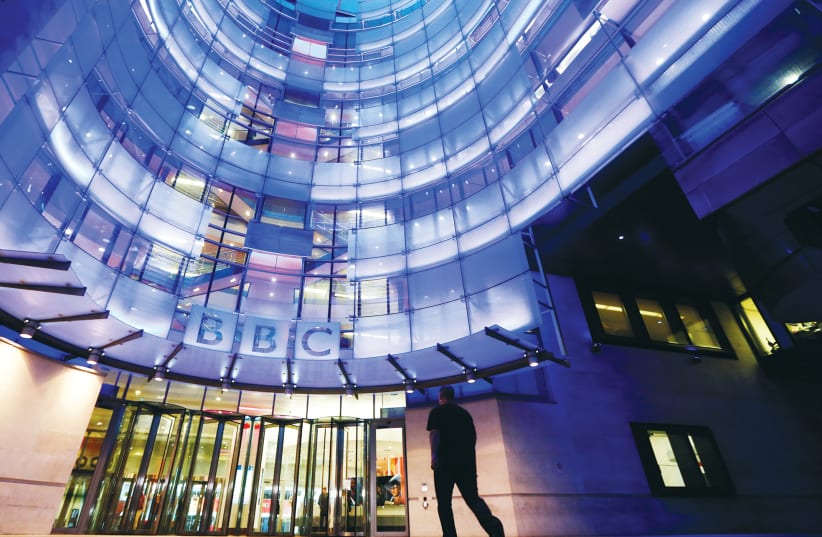 A MAN ENTERS BBC’s New Broadcasting House in London (photo credit: LUKE MACGREGOR / REUTERS)