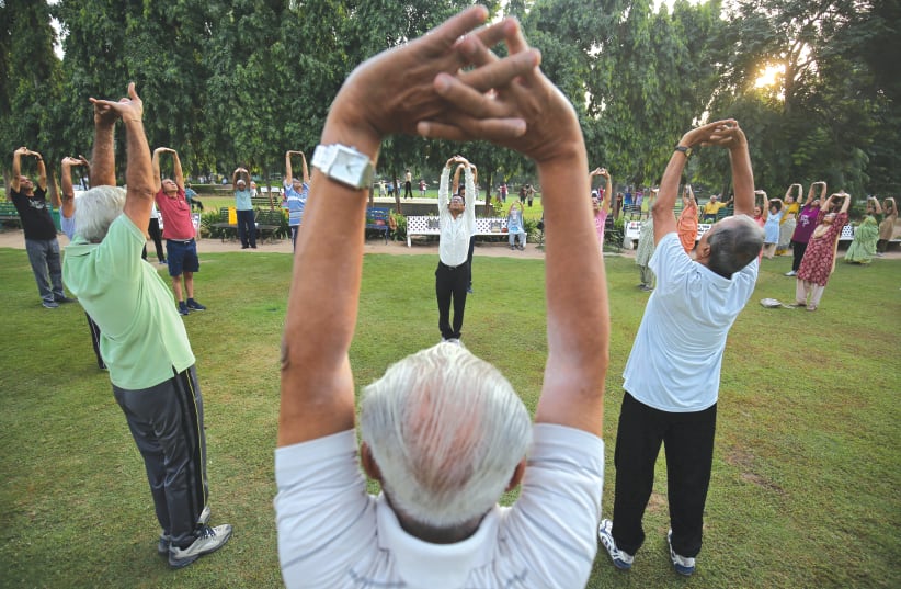 Senior citizens participate in laughter yoga in a park in India. (photo credit: AMIT DAVE)