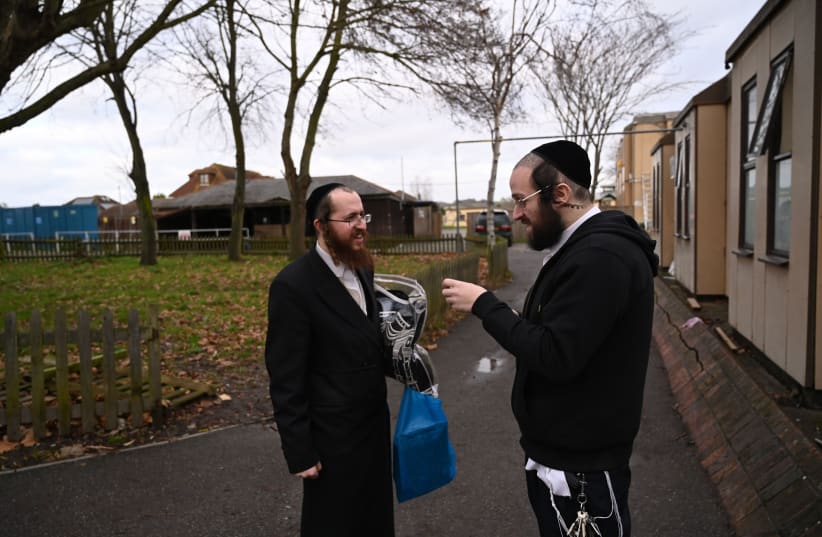 Jacob Gross, right, speaking to a resident of Canvey Island, UK outside the town's synagogue on Dec. 13, 2019.  (photo credit: CNAAN LIPHSHIZ/JTA)