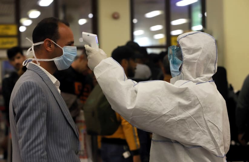 Passengers wearing masks, amid the new coronavirus outbreak, are checked by Iraqi Health Ministry employees upon their arrival at Basra airport, in Basra, Iraq February 1, 2020 (photo credit: REUTERS/ESSAM AL-SUDANI)