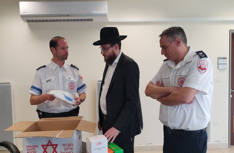 Rabbi Eliyahu Rosenberg of Chabad of Guangzhou, China examines MDA supplies to be sent to 14 Chabad houses throughout China in an attempt to prevent the spread of coronavirus (photo credit: MAGEN DAVID ADOM)